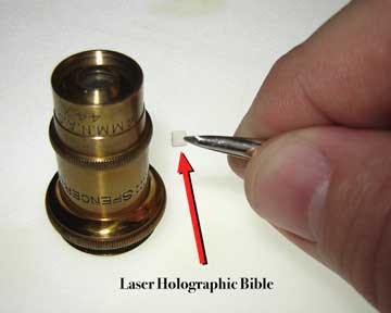 The Hologram Bible is held by a pair of tweezers.