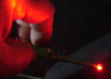 The photopolymer film glows as it is struck with the light from a laser.